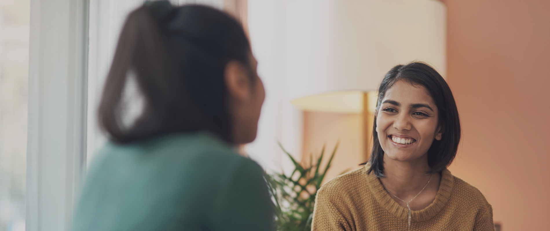 A woman smiling at another woman. South Asian creative arts therapy center in Melbourne – Opt for healing through movement and mindfulness. Book your session with Kathaprana now.
