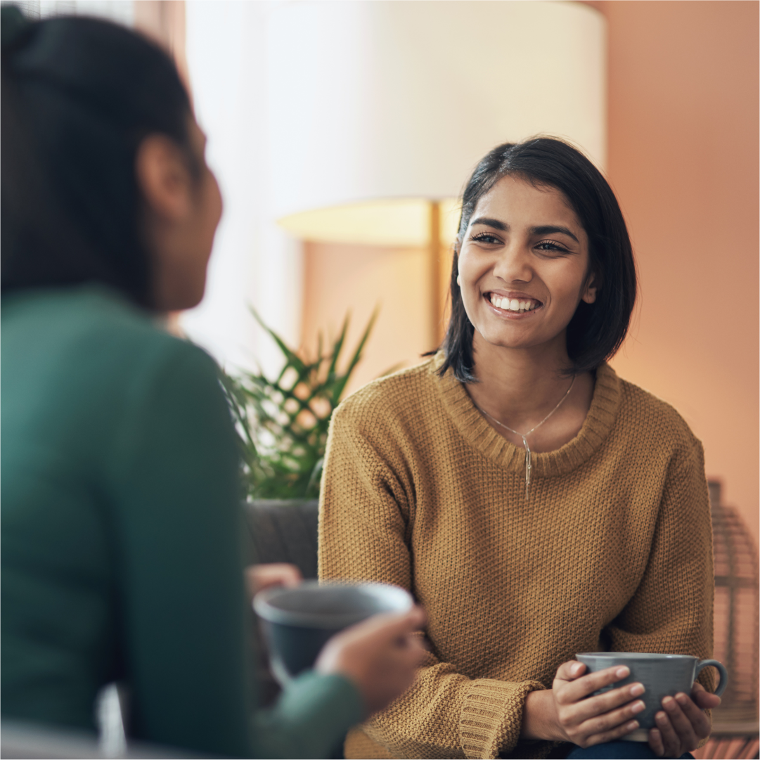 A woman sitting on a couch smiling at her therapist. South Asian Individual Therapy center in Melbourne – Opt for healing through movement and mindfulness with Kathaprana.